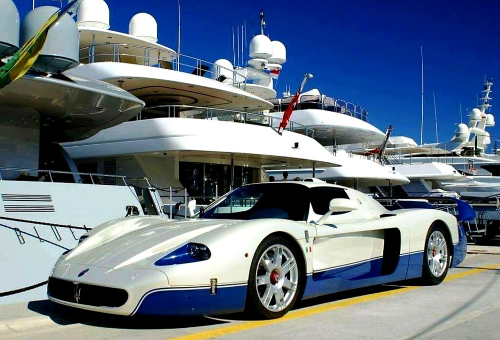 Supercar in front of yachts in a marina 