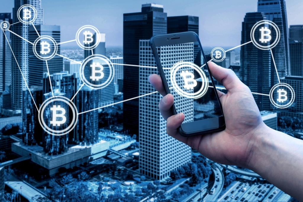 Crypto Payments : smartphone with Bitcoins in front of building
